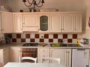a kitchen with white cabinets and a sink at Villa Silvana in Magazzini