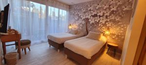 a small room with two beds and a window at Hotel Tennis International in Cap d'Agde