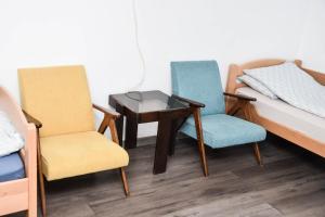 a room with two chairs and a table and a bed at Dunja in Sivac