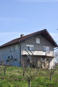 a gray house with a porch and a balcony at Dunja in Sivac
