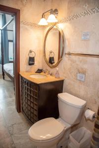 a bathroom with a toilet and a sink and a mirror at Ocean Bliss: Balcony & Pools & Peloton Bike! in Lowlands