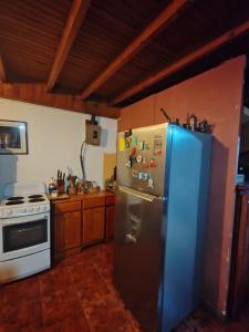 a kitchen with a stainless steel refrigerator and a stove at Mountain Chalet with Valley View in Alajuela +18 photos