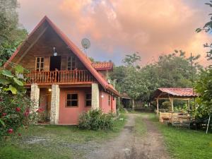 a house with a red roof and a yard at Mountain Chalet with Valley View in Alajuela