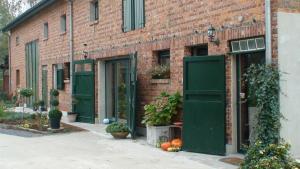 a brick building with green doors and plants on it at B&B Euverbraeke in Beveren