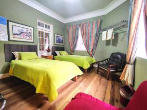 Un dormitorio con dos camas y una silla. en Hospedaje CASA REAL, en Huancayo