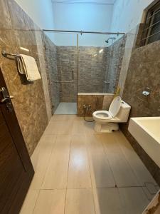 a bathroom with a toilet and a shower and a sink at Comfort Family Villa Islamabad in Islamabad +39 photos