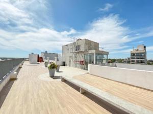 a rooftop deck with a view of a building at Alojate en METRA Puerto Norte, luminoso estudio con pileta, gym y balcon in Rosario