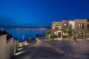 a house with a view of the water at night at Olive Hill House - first floor in Slatine