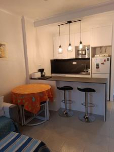 kuchnia z blatem i dwoma krzesłami barowymi w obiekcie Residencia Alhambra Los Cisnes w mieście Torrevieja