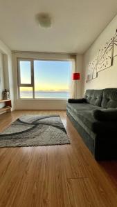 a living room with a couch and a large window at Costa Beagle in Ushuaia