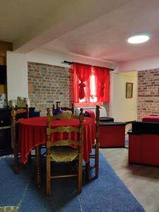 Habitación con mesa y mantel rojo. en OTAM Villa, en Pogradec