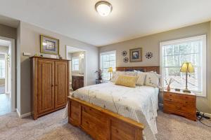 une chambre avec un lit et une commode et deux fenêtres dans l'établissement Gap Creek Cottage, à Fletcher