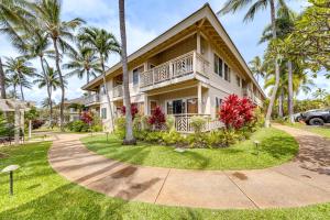 a house with palm trees in front of it at Poipu Kai Resort Vacation Condo in Koloa! in Koloa