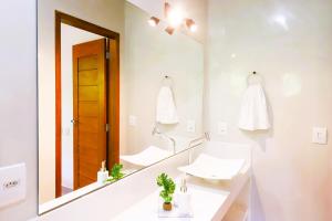a bathroom with a sink and a mirror at #2 Flat das Oliveiras Pipa Private Jacuzzi and AR in Pipa