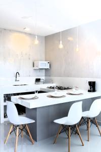 a kitchen with white counters and white chairs at #2 Flat das Oliveiras Pipa Private Jacuzzi and AR in Pipa +15 photos