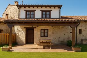 a wooden picnic table in front of a house at El Jardín de Casa Male in Pimiango +21 photos