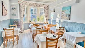 a restaurant with tables and chairs and a window at Tusker Lodge in Torquay