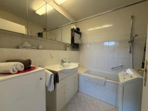a bathroom with a sink and a tub and a mirror at Ferienwohnung Thurner in Bad Reichenhall