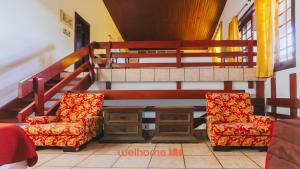 a living room with two chairs and a table at Casa de Praia no Guaruja com SPA e Piscina in Guarujá