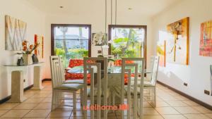 a dining room with a glass table and chairs at Casa de Praia no Guaruja com SPA e Piscina in Guarujá