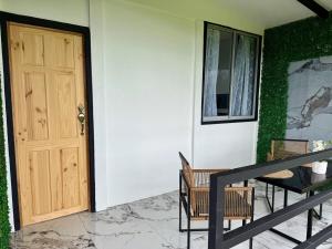 a front door of a house with two chairs and a table at Mini Casa Aura in Fortuna