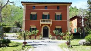 a large orange house with a balcony on top of it at Villa Storica Calderino in Monte San Pietro