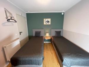 a room with two beds and a table with a lamp at Urban Bliss Newly Renovated in Nürnberg