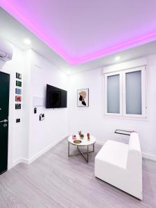 Una sala de estar con un sofá blanco y una mesa. en La Placita Boutique Trinidad, en Málaga
