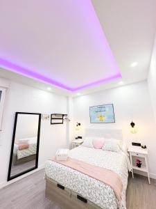 Un dormitorio blanco con una cama y un espejo. en La Placita Boutique Trinidad, en Málaga