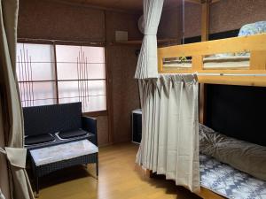 a bedroom with a bunk bed with a couch and a chair at Stay 貝飾り in Oshamambe