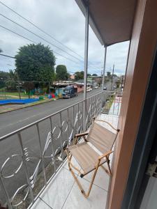 a chair sitting on a balcony overlooking a street at Depa Koral in Puerto Limón