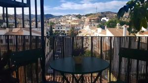 a table on a balcony with a view of a city at Apartamento Marion in Cala del Moral