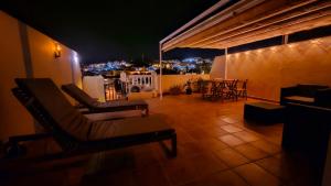 a balcony with chairs and a view of a city at night at Apartamento Marion in Cala del Moral