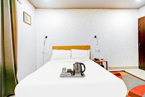 a bedroom with a white bed with a sewing machine on it at Townhouse Volga Homes in Guwahati