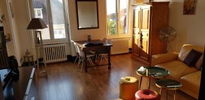 a living room with a couch and a table at Au kouglof avec Netflix in Colmar +12 photos