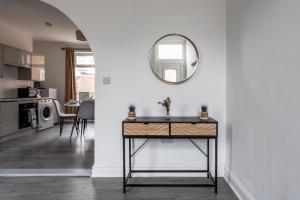 a living room with a table and a mirror at Elm View Retreat in Durham