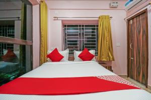 a bedroom with a bed with red pillows and a window at Collection O NEOSTAY TOWN HOUSE in Kolkata