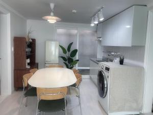 a kitchen with a white table and a table and chairs at Stay In Itaewon in Seoul