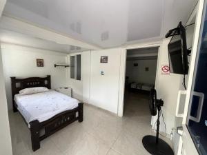 a bedroom with a bed and a flat screen tv at Nature View in Providencia