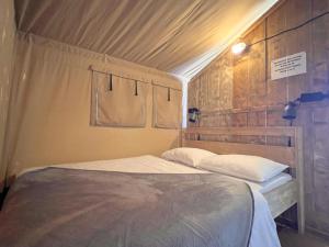 a bed with two pillows in a room at De Bij in Hulshorst