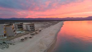 a beach with umbrellas and the ocean at sunset at Amina Wind Resort by Tasman in Salinas