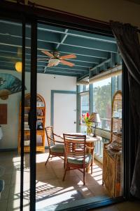 a dining room with a table and chairs and a ceiling fan at Lanai Villas in Koloa