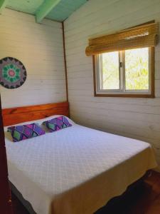 ein Bett in einem Zimmer mit Fenster in der Unterkunft cabaña cuatro reinas in Tigre