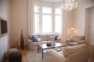 ブダペストにあるCity Apartment Budapestのリビングルーム(ソファ、椅子、テーブル付)