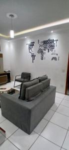 a couch sitting in a living room with a wall at Casa Aconchegante in Espirito Santo Do Pinhal