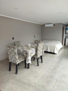 a dining room with a table and chairs and a bed at Buena Estadia in Villa María