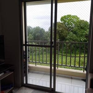 Une porte ouverte s'ouvre sur un balcon avec vue sur les arbres. dans l'établissement Home COP 30, à Belém