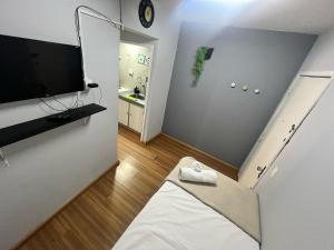 una pequeña sala de estar con cama y TV. en Flat Av Rio Branco 185 Cond Metrô Lapa RJ, en Río de Janeiro
