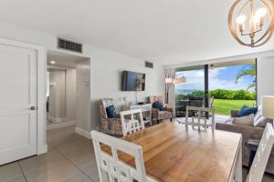 a dining room and living room with a table and chairs at KIHEI BEACH, #109 condo in Kihei