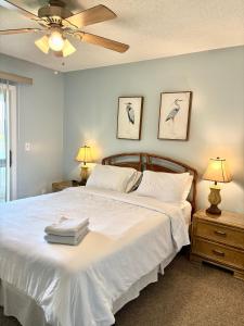 a bedroom with a large white bed with two lamps at Elegant 3-Bedroom Condo in Lewes with Pond Views in The Plantations
